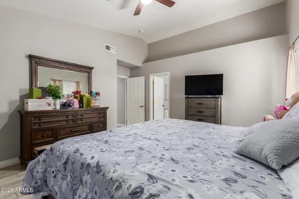 a bed room with a bed a television and dresser