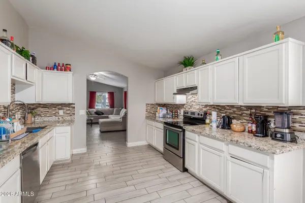 a kitchen with a stove top oven and cabinets
