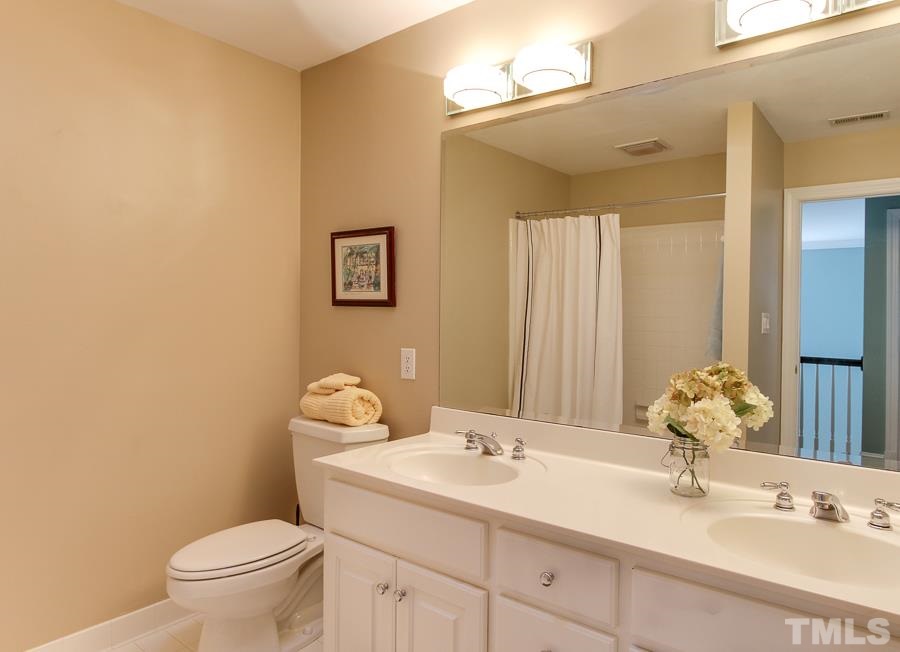 2040 Ridge Road Raleigh, NC 27607 - Photo 22 of 25 Nice neutral tiled bath upstairs with double vanity.