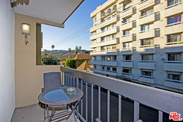 a view of a building from a chairs and table in the balcony