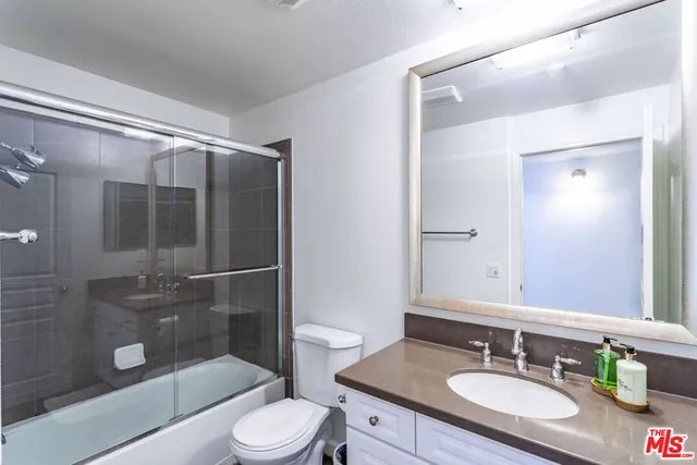 a bathroom with a sink granite toilet and shower