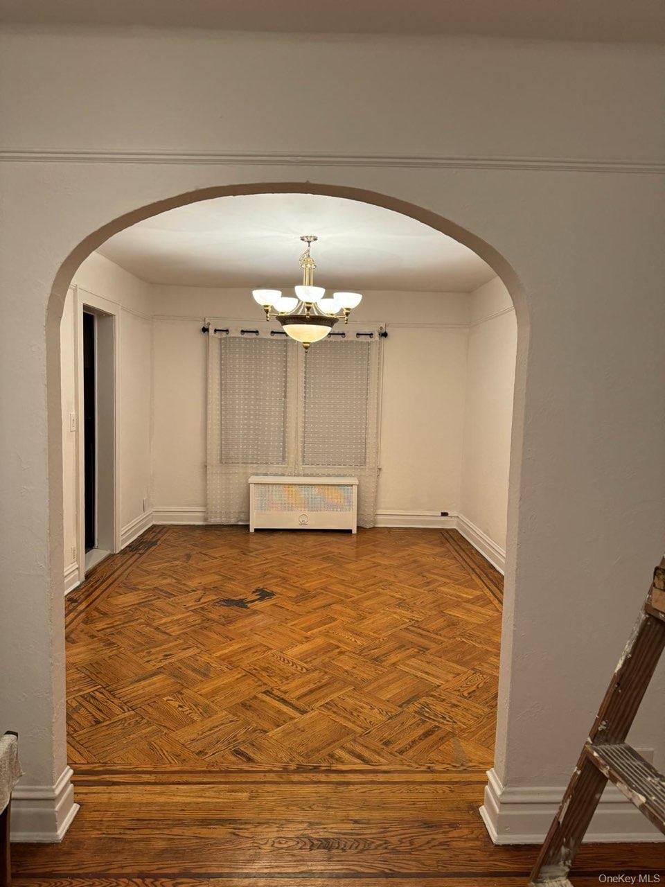 114-25 201st Street Queens, NY 11412 - Photo 4 of 18 Hall with arched walkways and a chandelier