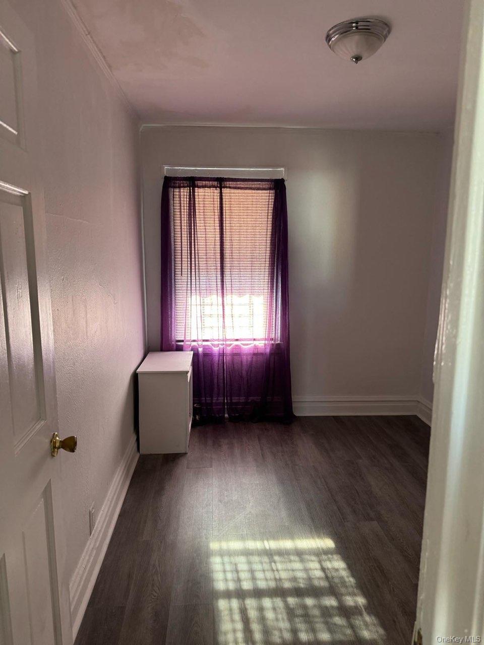 114-25 201st Street Queens, NY 11412 - Photo 7 of 18 Empty room featuring dark wood finished floors and baseboards