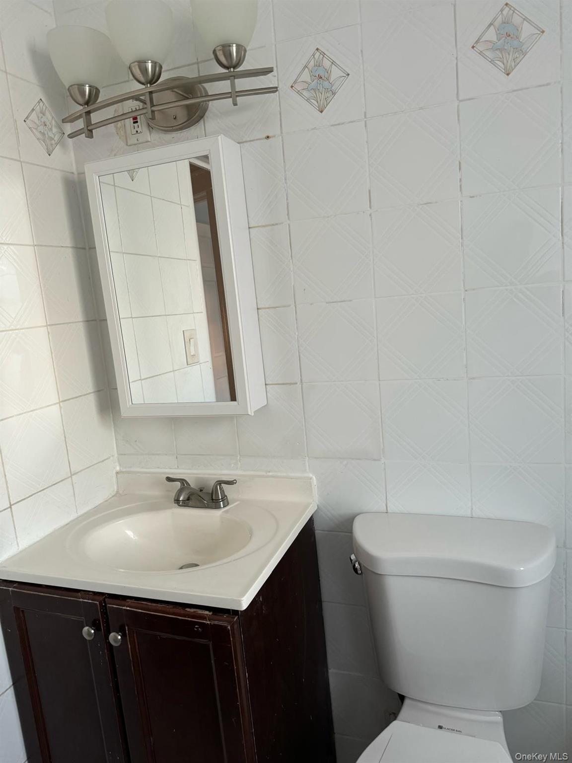 114-25 201st Street Queens, NY 11412 - Photo 9 of 18 Half bathroom featuring tile walls and vanity