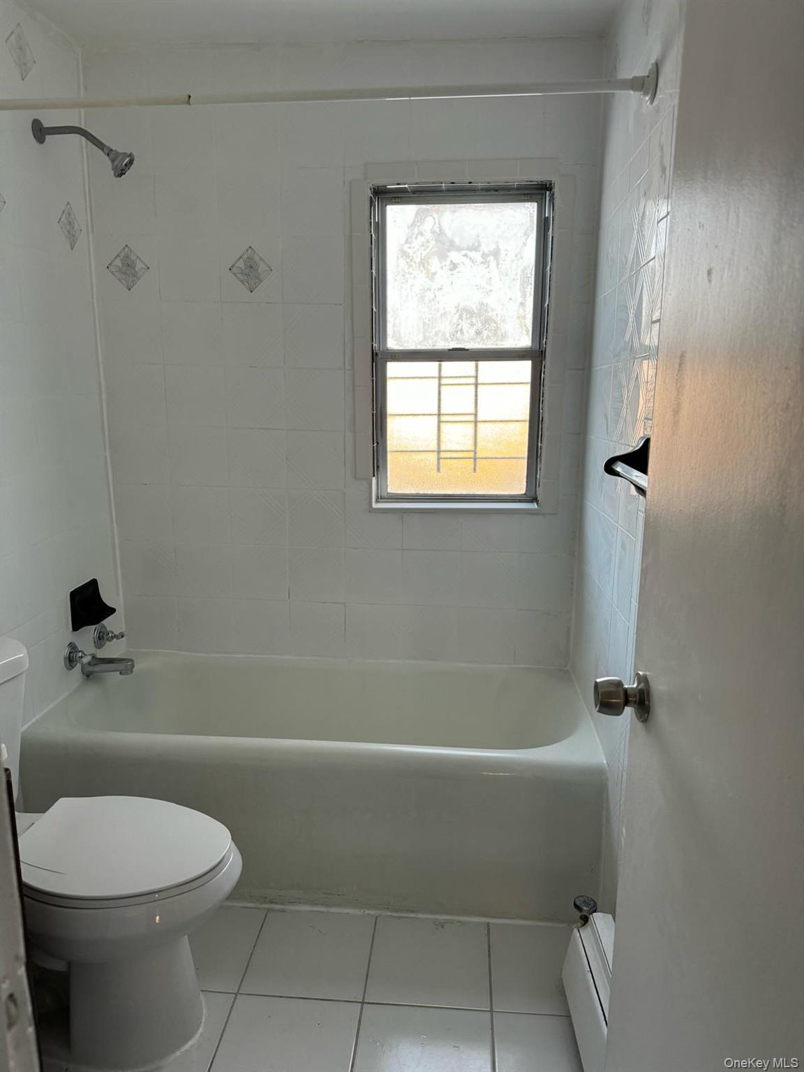 114-25 201st Street Queens, NY 11412 - Photo 10 of 18 Full bath with tub / shower combination, light tile patterned floors, a baseboard radiator, and vanity