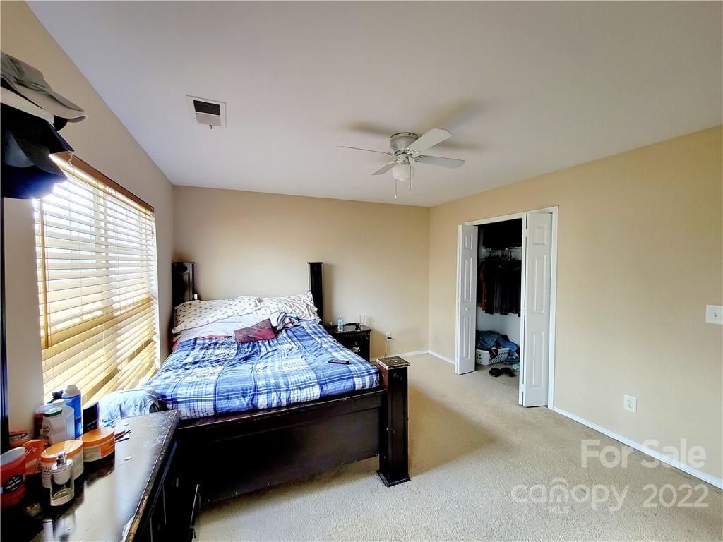 4724 Meadowfield Road Charlotte, NC 28215 - Photo 14 of 29 a bedroom with a bed and a potted plant