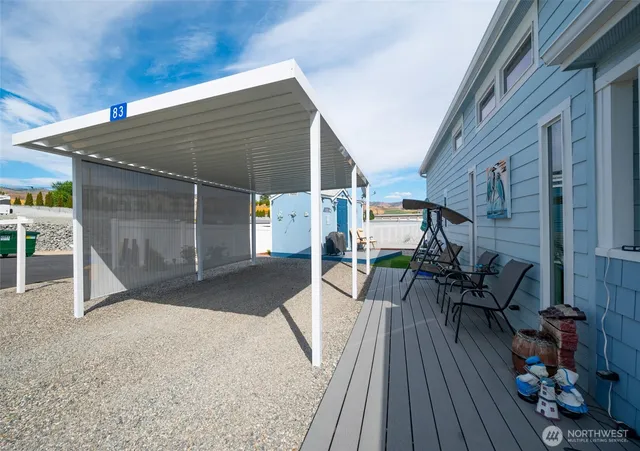 a view of a patio with table and chairs with wooden floor and fence