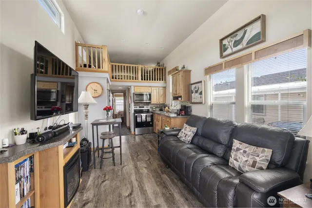 a living room with furniture a flat screen tv and a floor to ceiling window