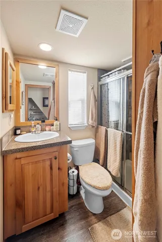 a bathroom with a granite countertop toilet sink and mirror