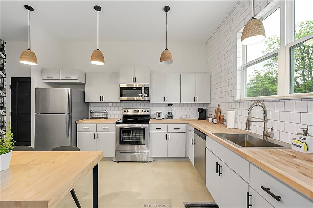 603 South Sims Avenue, Unit 113 Bryan, TX 77803 - Photo 6 of 10 a kitchen with white cabinets stainless steel appliances and window