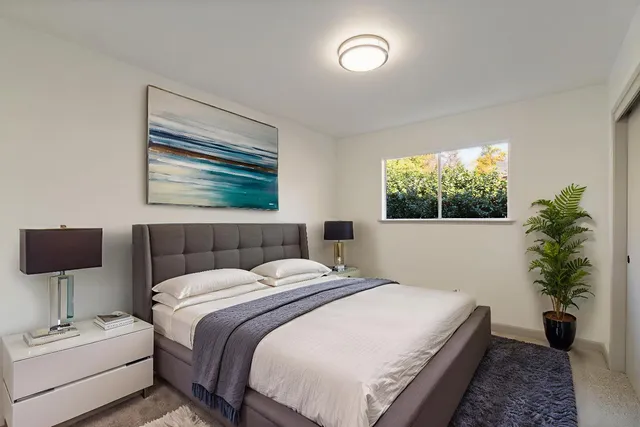 a bedroom with a bed and a potted plant