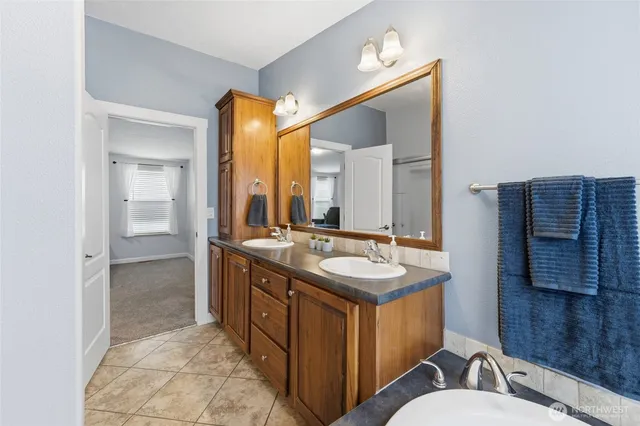 a bathroom with a granite countertop sink mirror and a bathtub