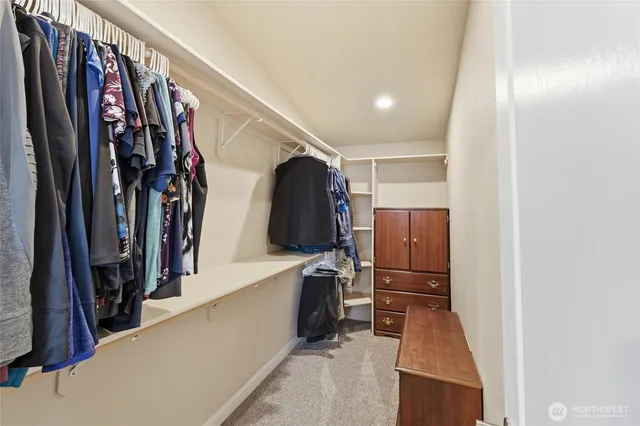 a view of walk in closet with clothes and shoes