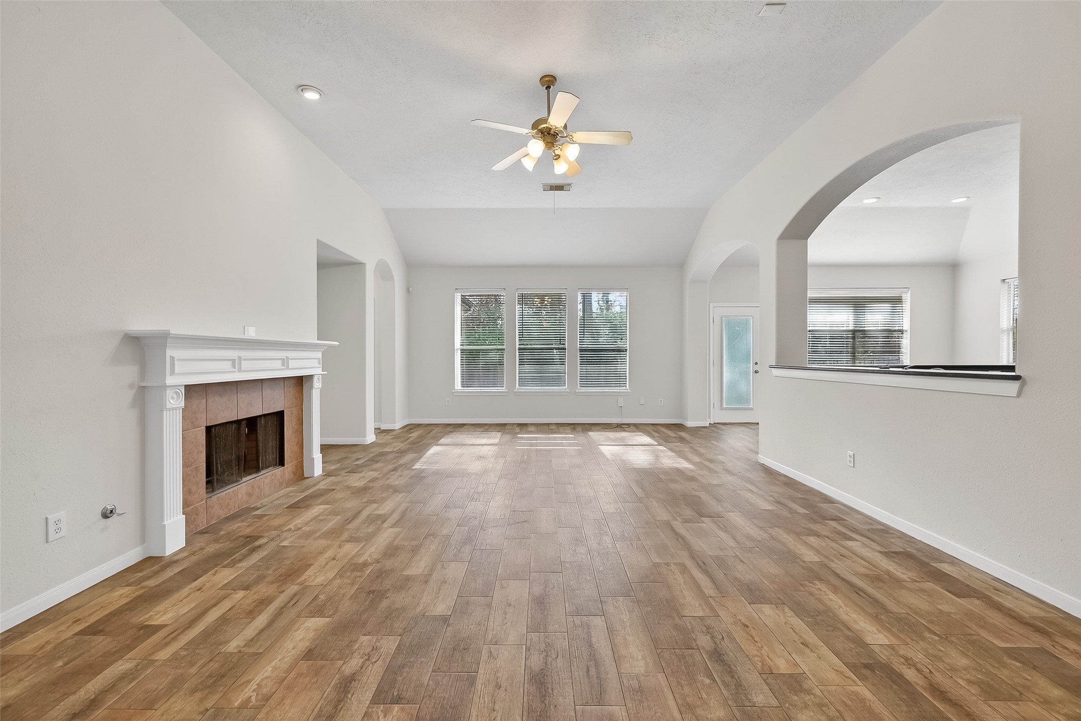 78 South Archwyck Circle Spring, TX 77382 - Photo 13 of 47 a view of an empty room with wooden floor fireplace and a window
