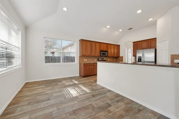 a view of empty room with window and wooden floor