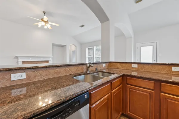 a kitchen with granite countertop a refrigerator and a sink