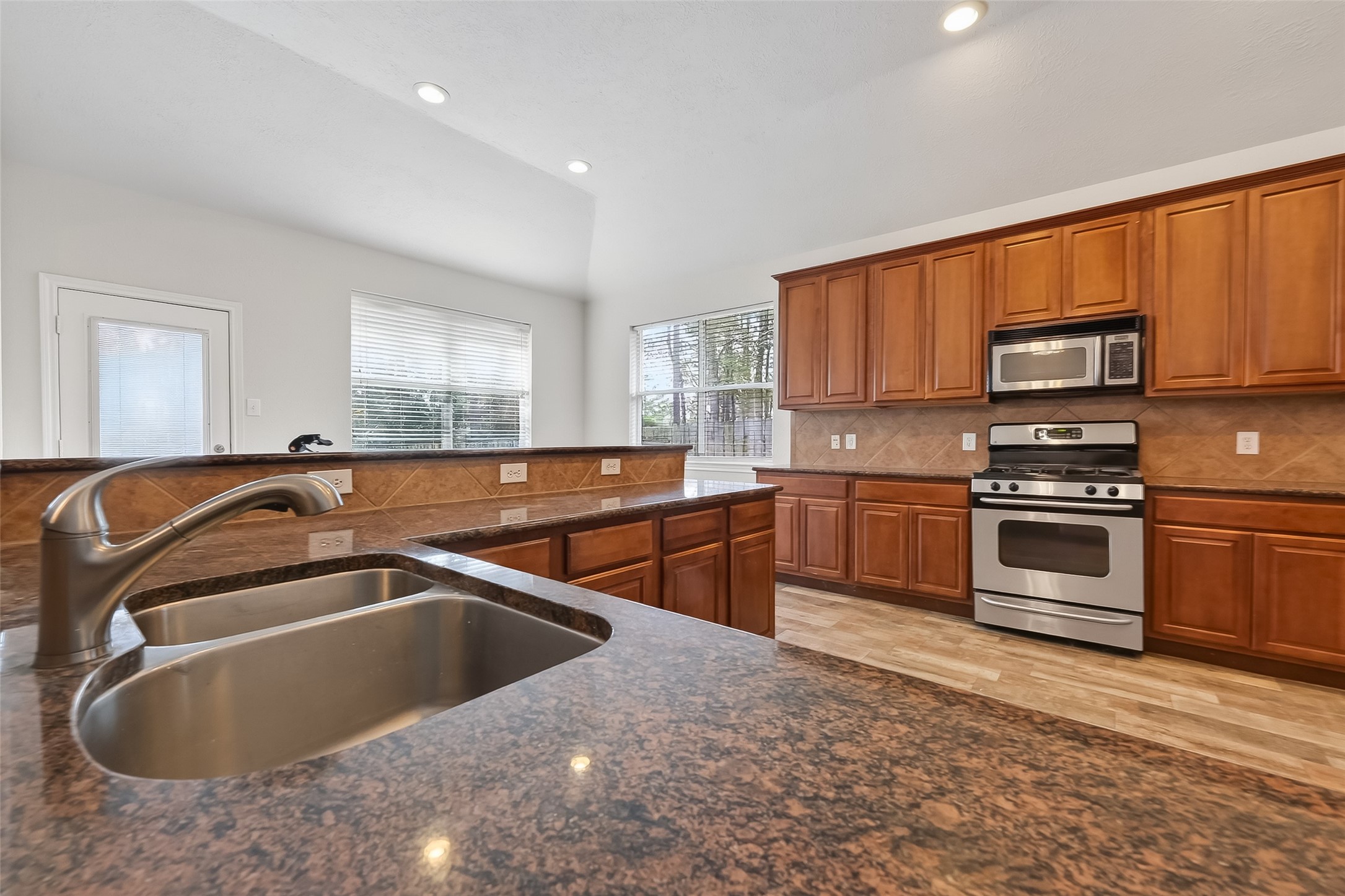 78 South Archwyck Circle Spring, TX 77382 - Photo 25 of 47 a kitchen with stainless steel appliances granite countertop a sink and a stove top oven