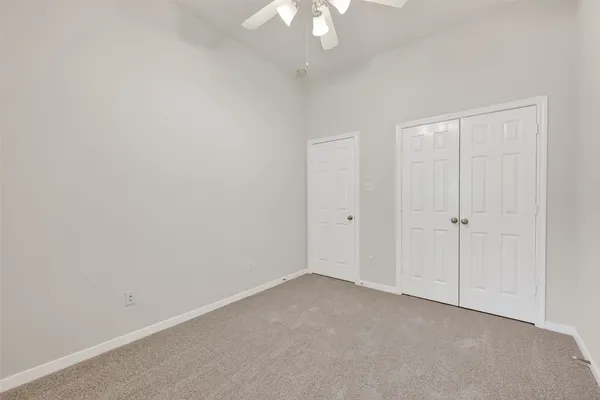 an empty room with a window and a fan