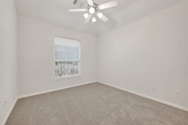 an empty room with a chandelier fan