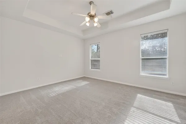 a view of an empty room with a ceiling fan and window