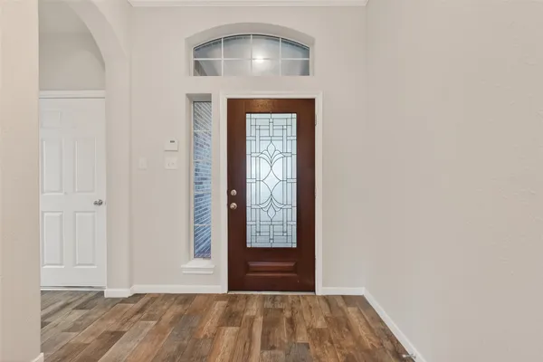 a view of a hallway with wooden floor and entryway