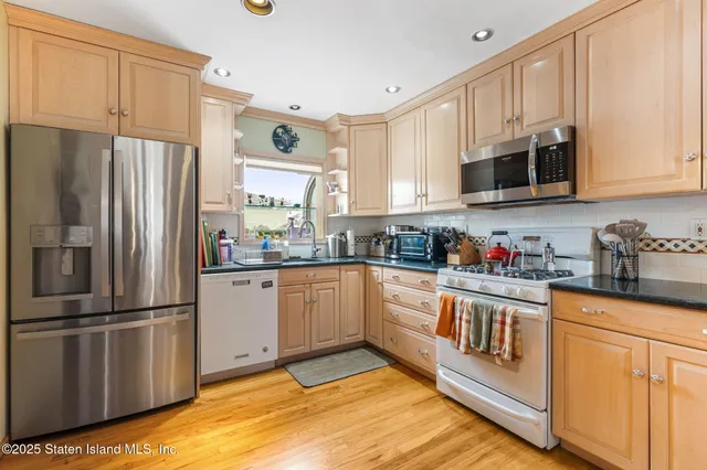 a kitchen with stainless steel appliances granite countertop a refrigerator sink and cabinets