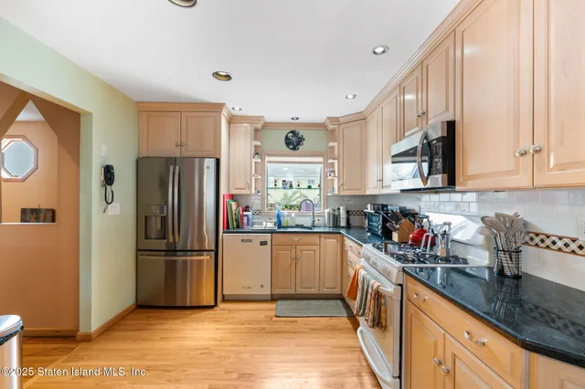 a kitchen with stainless steel appliances granite countertop a refrigerator and a sink