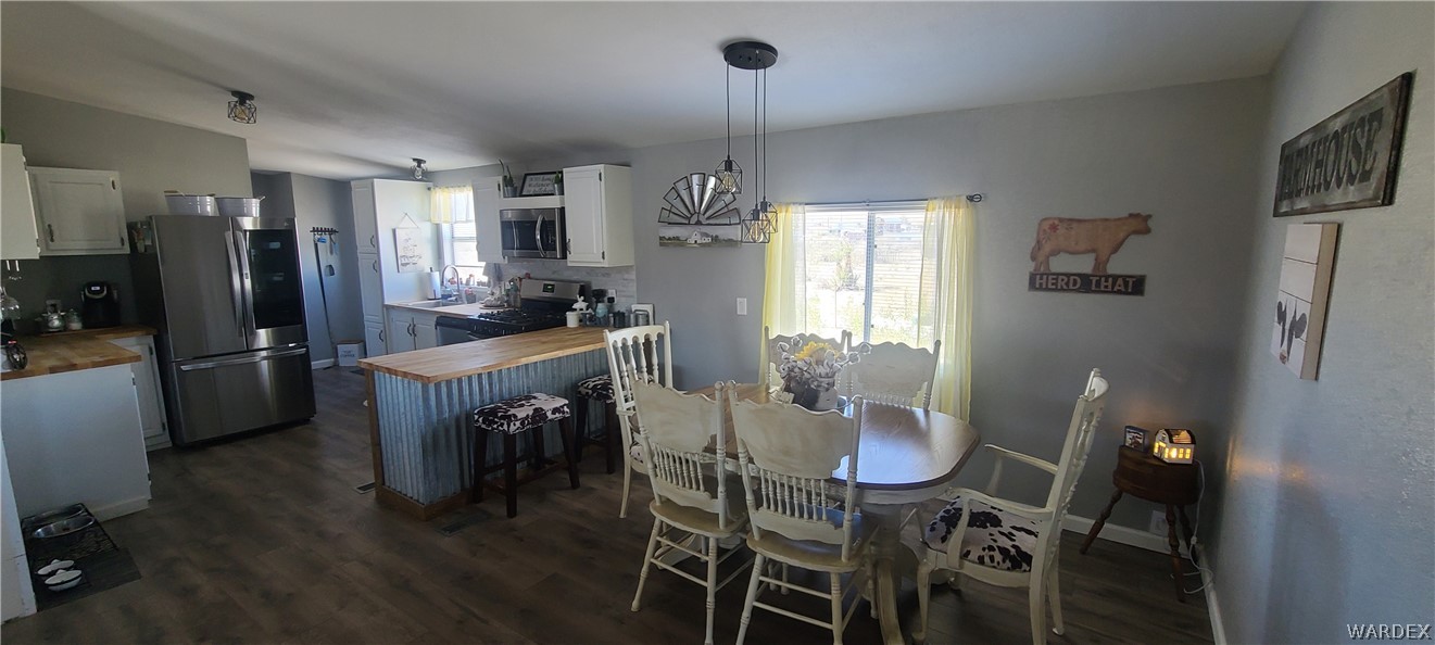 2821 Naco Road Golden Valley, AZ 86413 - Photo 32 of 71 a kitchen with refrigerator dining table and chairs