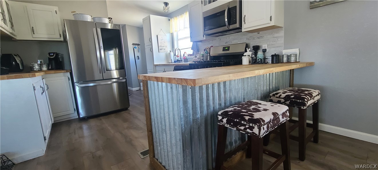 2821 Naco Road Golden Valley, AZ 86413 - Photo 36 of 71 a kitchen with stainless steel appliances granite countertop a refrigerator a stove a sink dishwasher and wooden cabinets with wooden floor