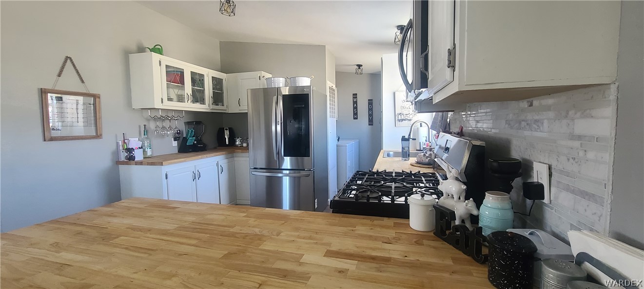 2821 Naco Road Golden Valley, AZ 86413 - Photo 39 of 71 a kitchen with stainless steel appliances kitchen island granite countertop a refrigerator a stove and a sink