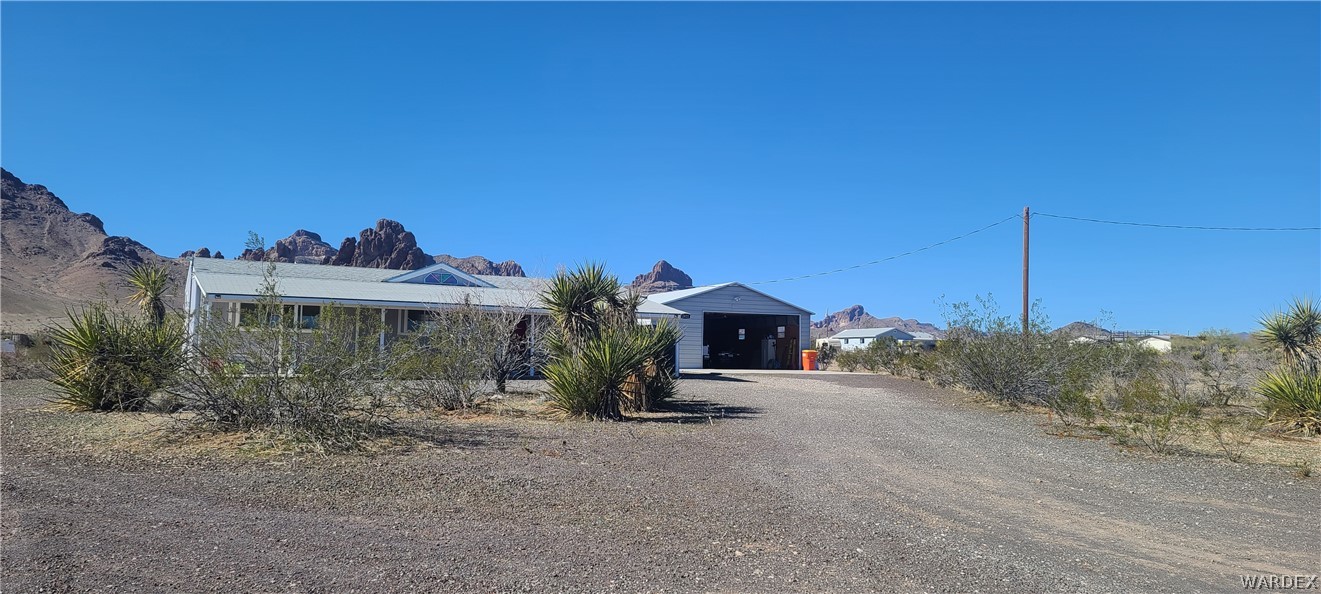 2821 Naco Road Golden Valley, AZ 86413 - Photo 8 of 71 a view of a house with a yard and table under an umbrella