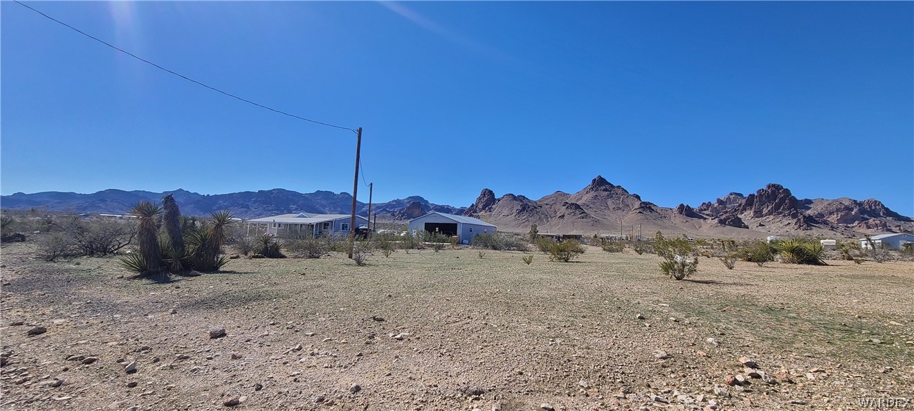 2821 Naco Road Golden Valley, AZ 86413 - Photo 10 of 71 a view of a dry yard with a mountain in the background
