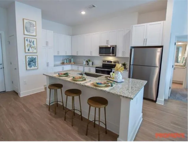 a kitchen with kitchen island a stove a table and chairs