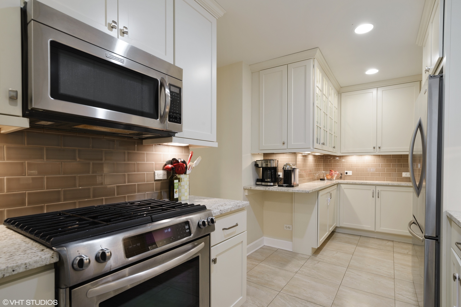 3100 North Sheridan Road, Unit 7D Chicago, IL 60657 - Photo 8 of 24 a kitchen with stainless steel appliances granite countertop a stove top oven microwave and cabinets