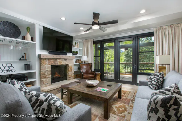 a living room with furniture a flat screen tv and a fireplace