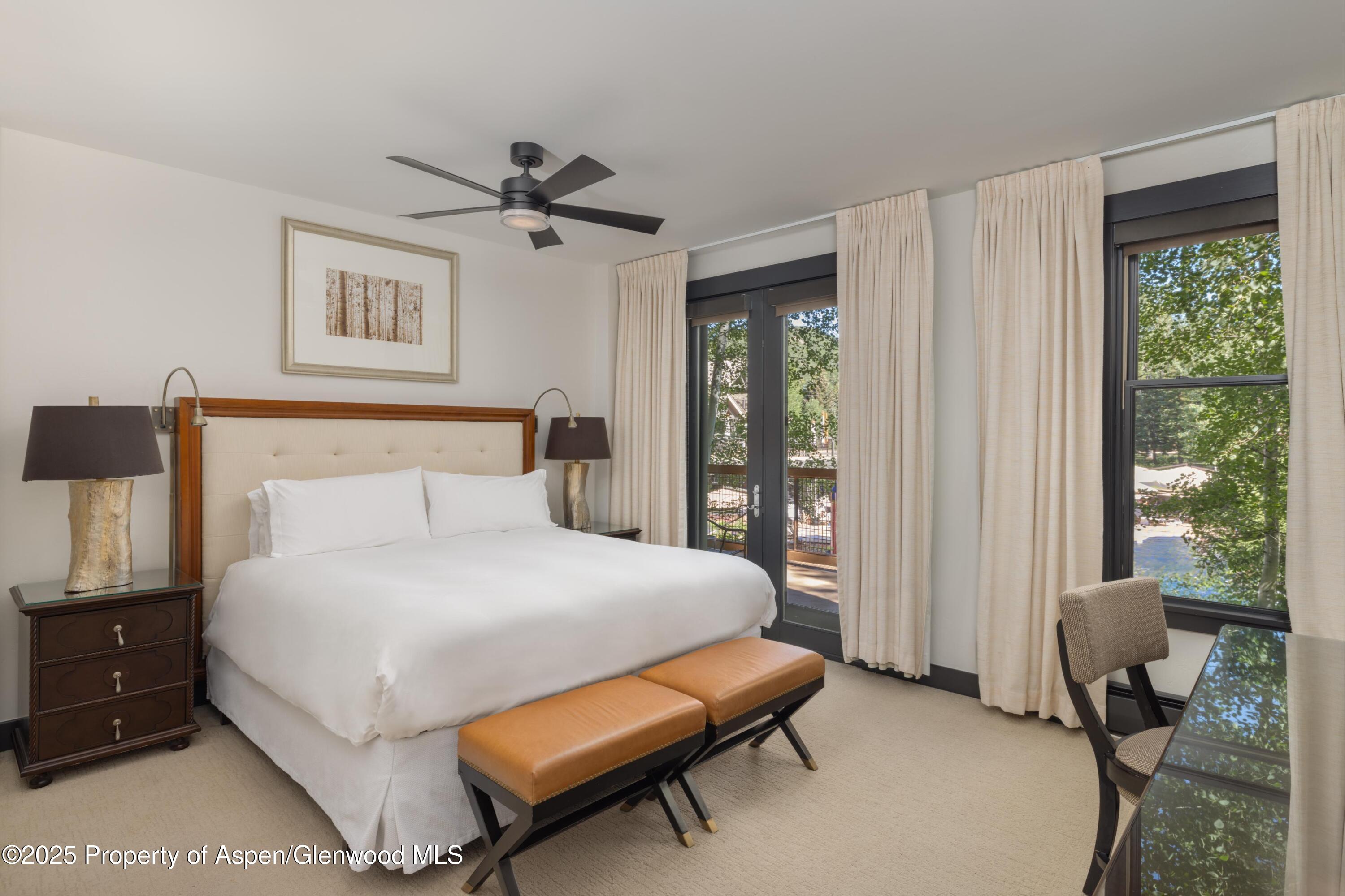 239 Snowmass Club Circle, Unit 111 Snowmass Village, CO 81615 - Photo 18 of 42 a bedroom with a bed and wooden floor