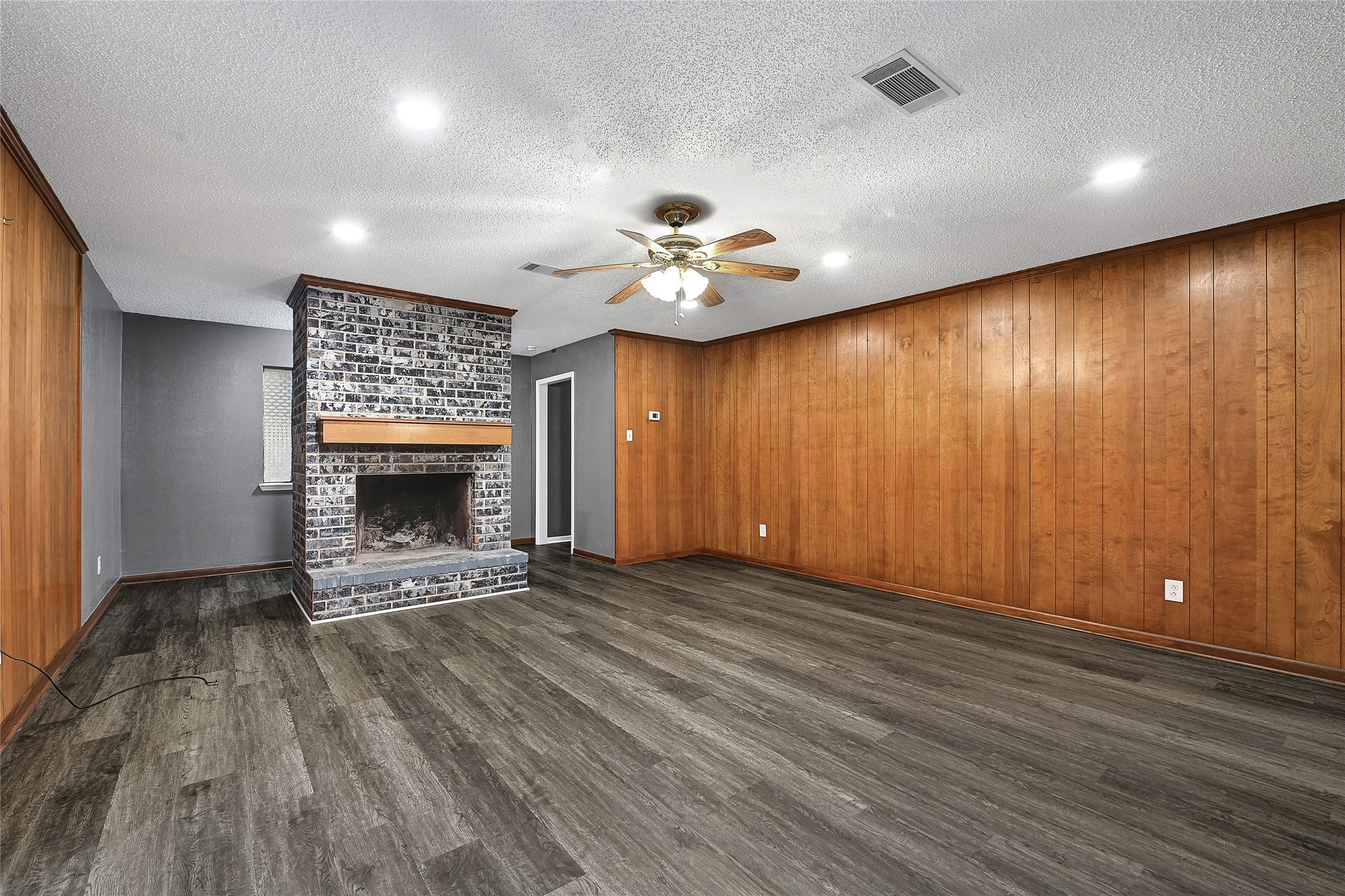 1712 Redwood Circle Alvin, TX 77511 - Photo 14 of 23 an empty room with windows and a fireplace