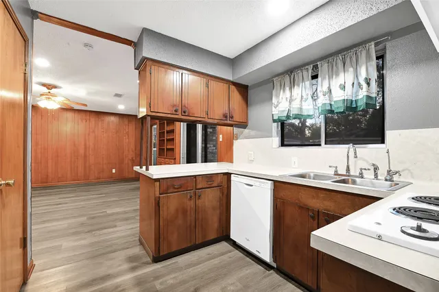 a kitchen with stainless steel appliances granite countertop a sink window and cabinets