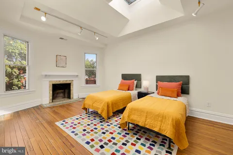 a bedroom with two beds and a fireplace