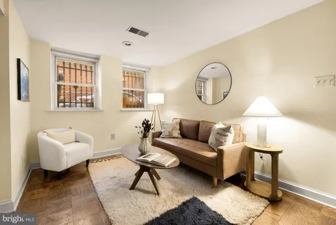 a living room with furniture a lamp and a window