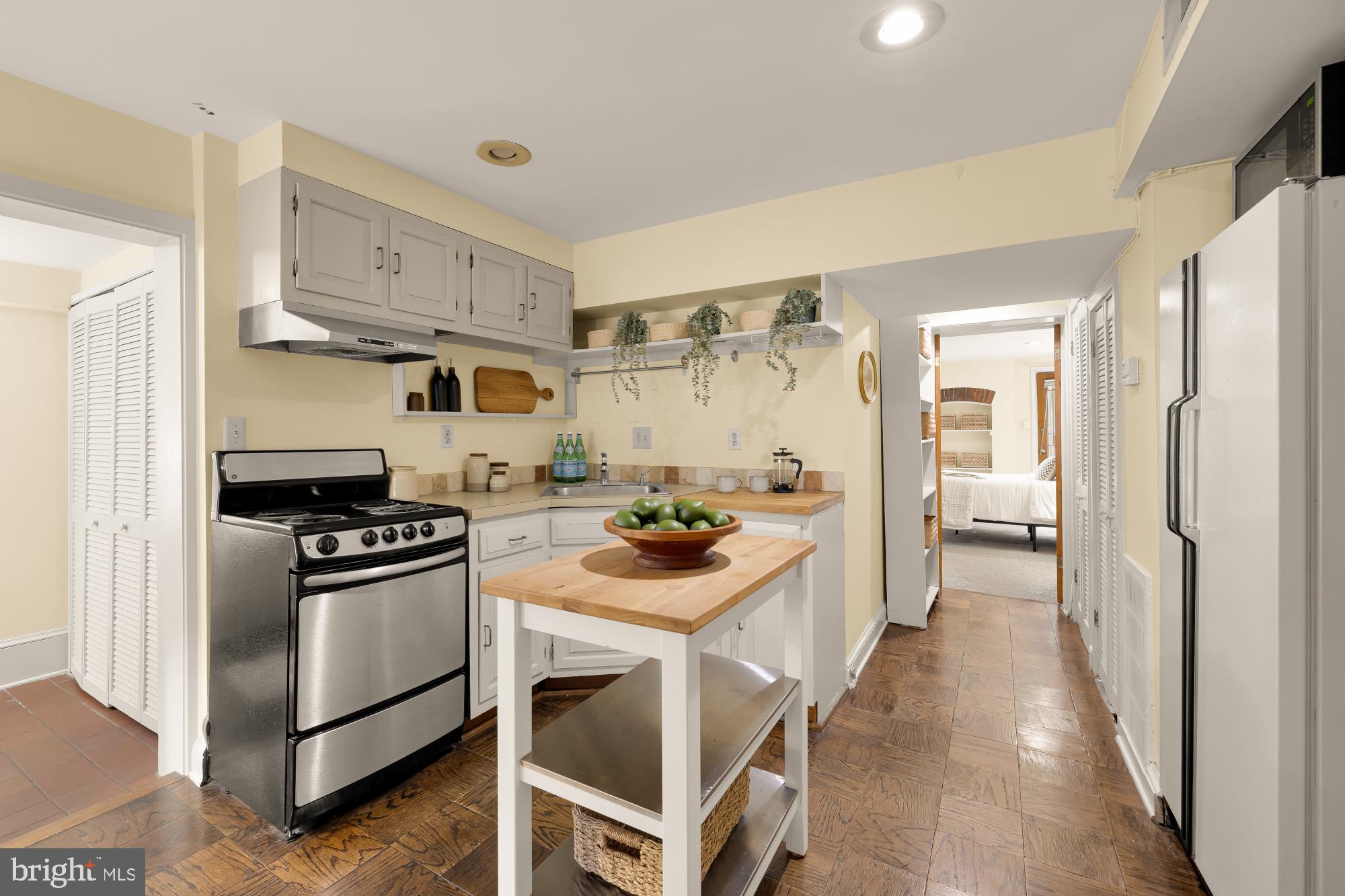1735 Riggs Place Northwest Washington, DC 20009 - Photo 16 of 35 a kitchen with white cabinets and stainless steel appliances