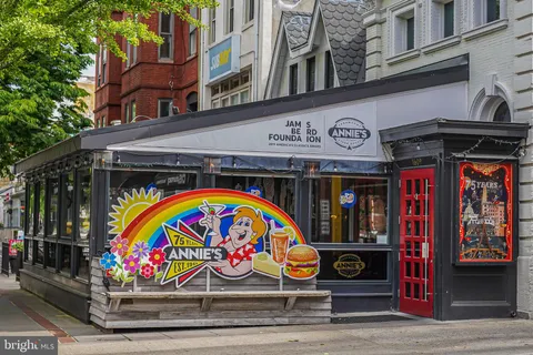 a view of sign board with buildings in the background