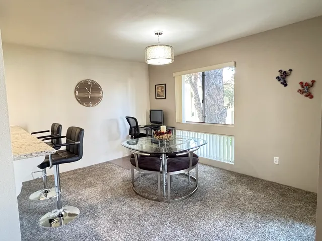 a living room with furniture and a view of kitchen