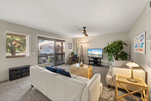a view of a hallway with wooden floor and a bathroom