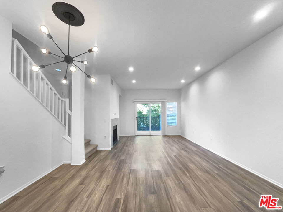 20000 Plum Canyon Road, Unit 1815 Santa Clarita, CA 91350 - Photo 11 of 21 a view of an empty room with wooden floor and a chandelier