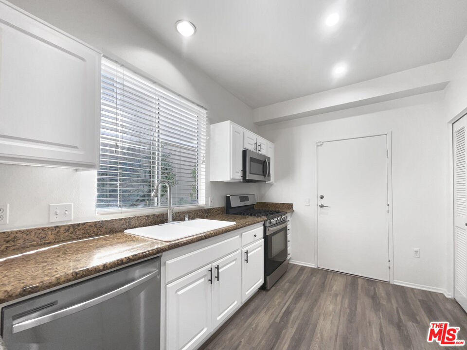 20000 Plum Canyon Road, Unit 1815 Santa Clarita, CA 91350 - Photo 14 of 21 a kitchen with granite countertop a sink and a stove