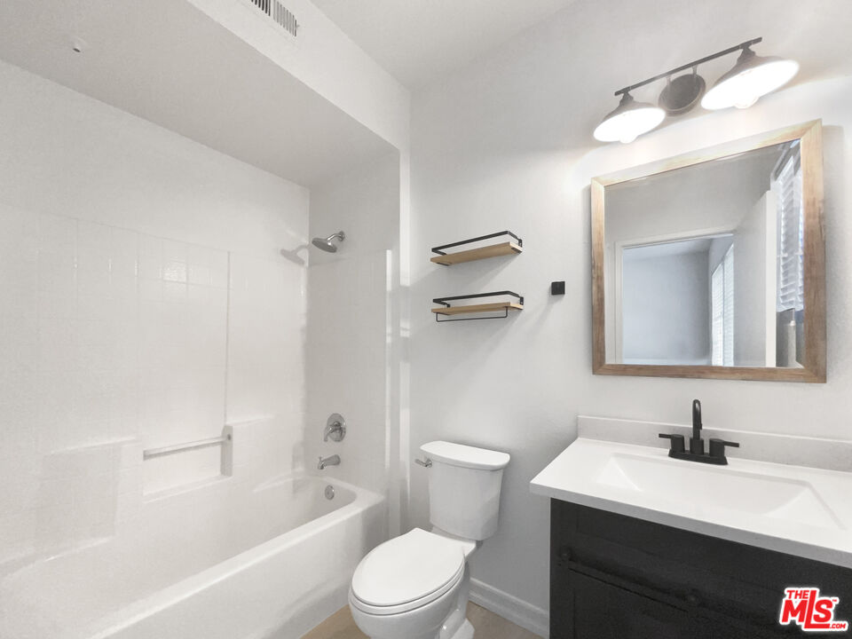 20000 Plum Canyon Road, Unit 1815 Santa Clarita, CA 91350 - Photo 8 of 21 a bathroom with a toilet a sink a mirror a bathtub and vanity