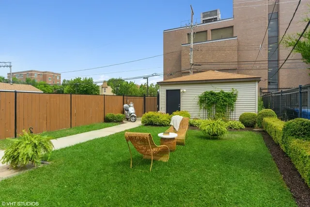a view of a chair and table in backyard of the house