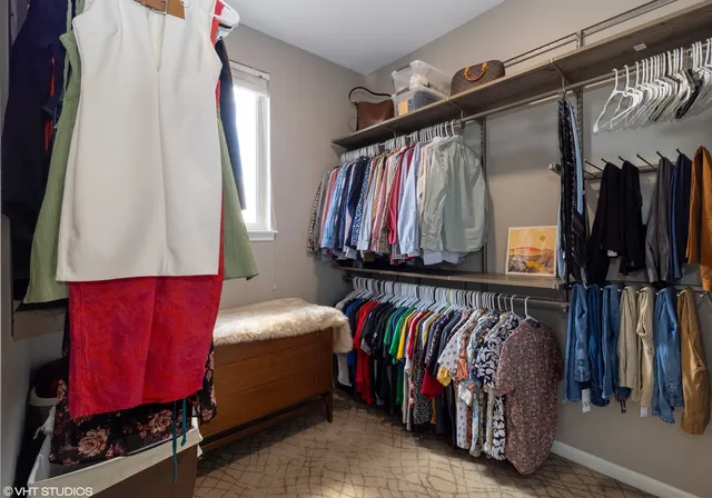 a view of walk in closet with clothes and shoes