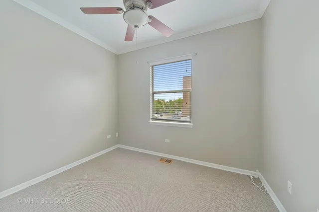 an empty room with a window and a fan